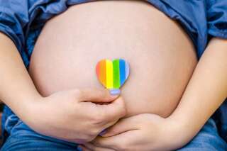 Pregnant woman shows on camera heart LGBT Pride Rights Lesbian Gay Bisexual Transgender Geek on city sunny day background. Pride mounth day
