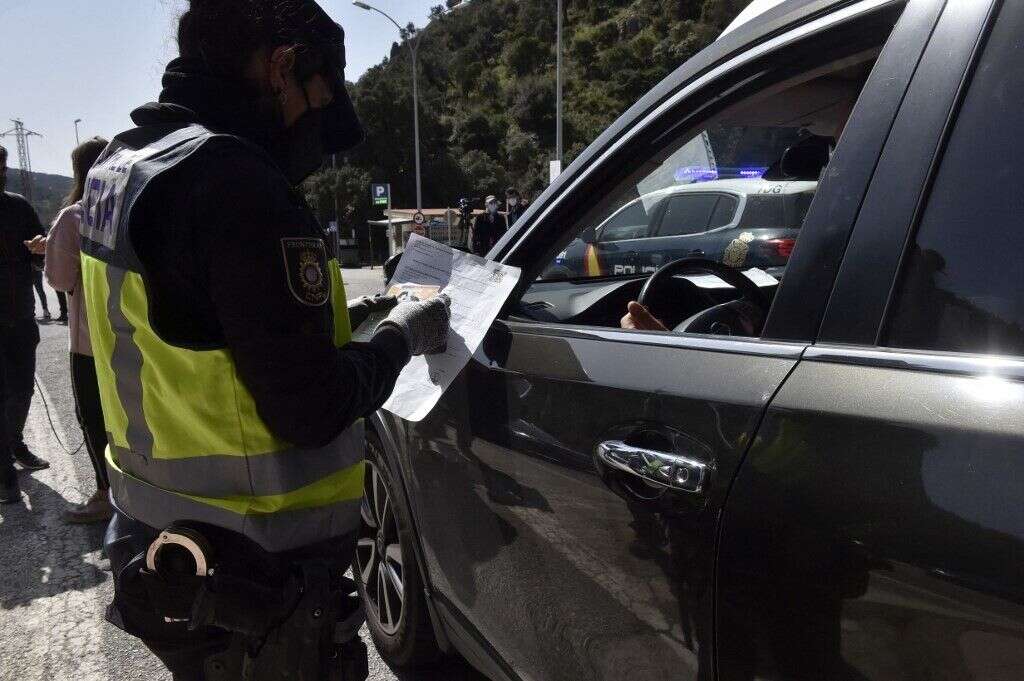 Un policier espagnol vérifie le test d'un automobiliste à la frontière avec la France, au Perthus, le 30 mars 2021.