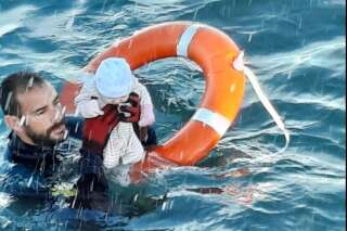 Un membre de la Garde civile espagnole sauve un bébé des eaux, à Ceuta en Espagne où des milliers de migrants sont arrivés à la nag