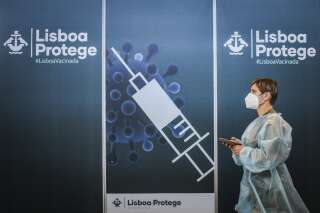 Un soignant passe devant le poster d'un centre de vaccination à Lisbonne, le 2 juillet 2021