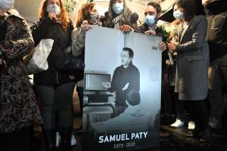 Des proches de Samuel Paty tenant une pancarte à son effigie lors d'une marche blanche à Conflans-Sainte-Honorine, le 20 octobre 2020