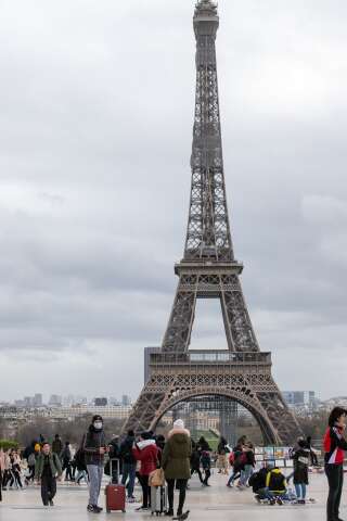 Des touristes devant la tour Eiffel à Paris le 12 mars 2020.