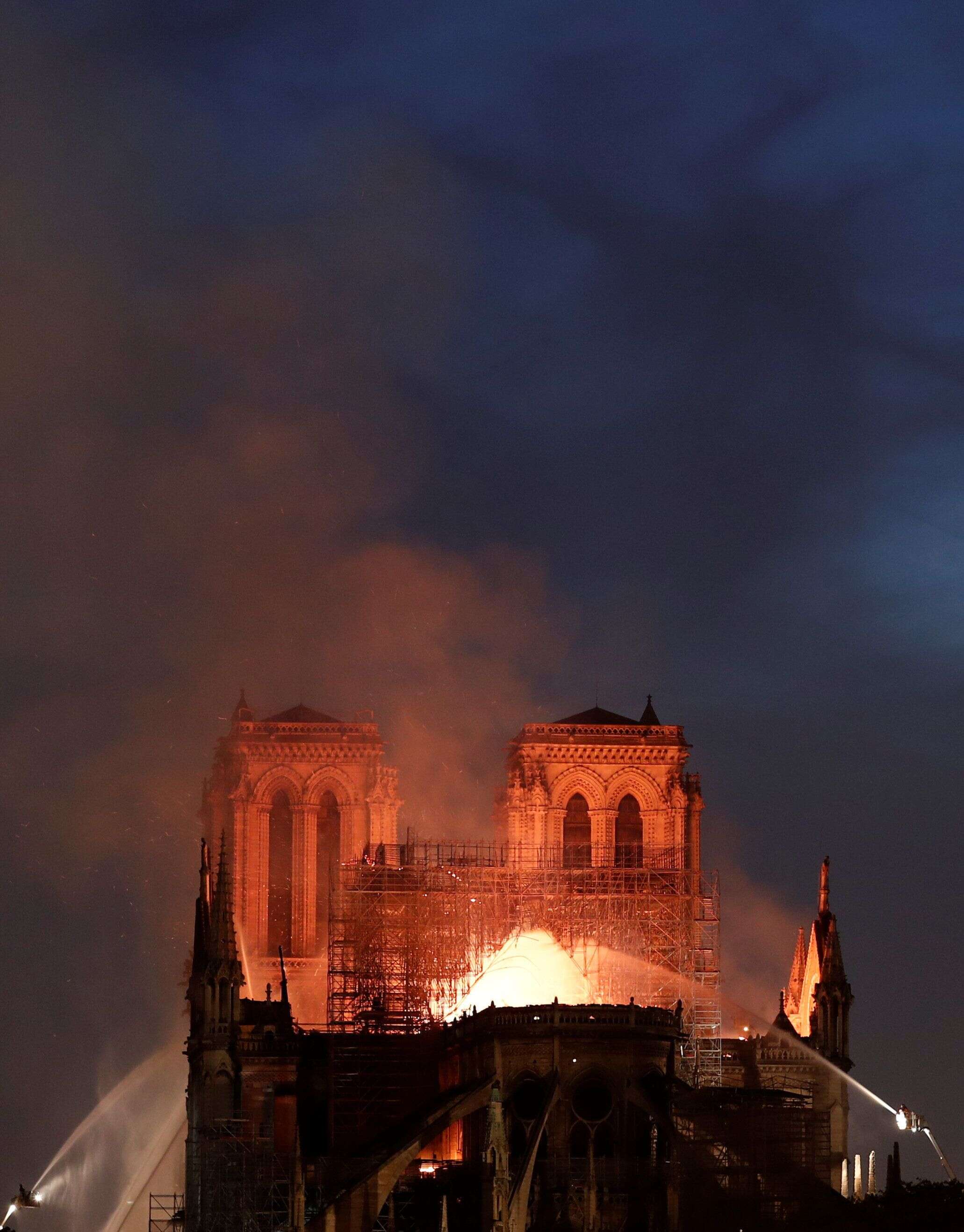 Firefighters douse flames from the burning Notre Dame Cathedral in Paris, France April 15, 2019. REUTERS/Benoit Tessier
