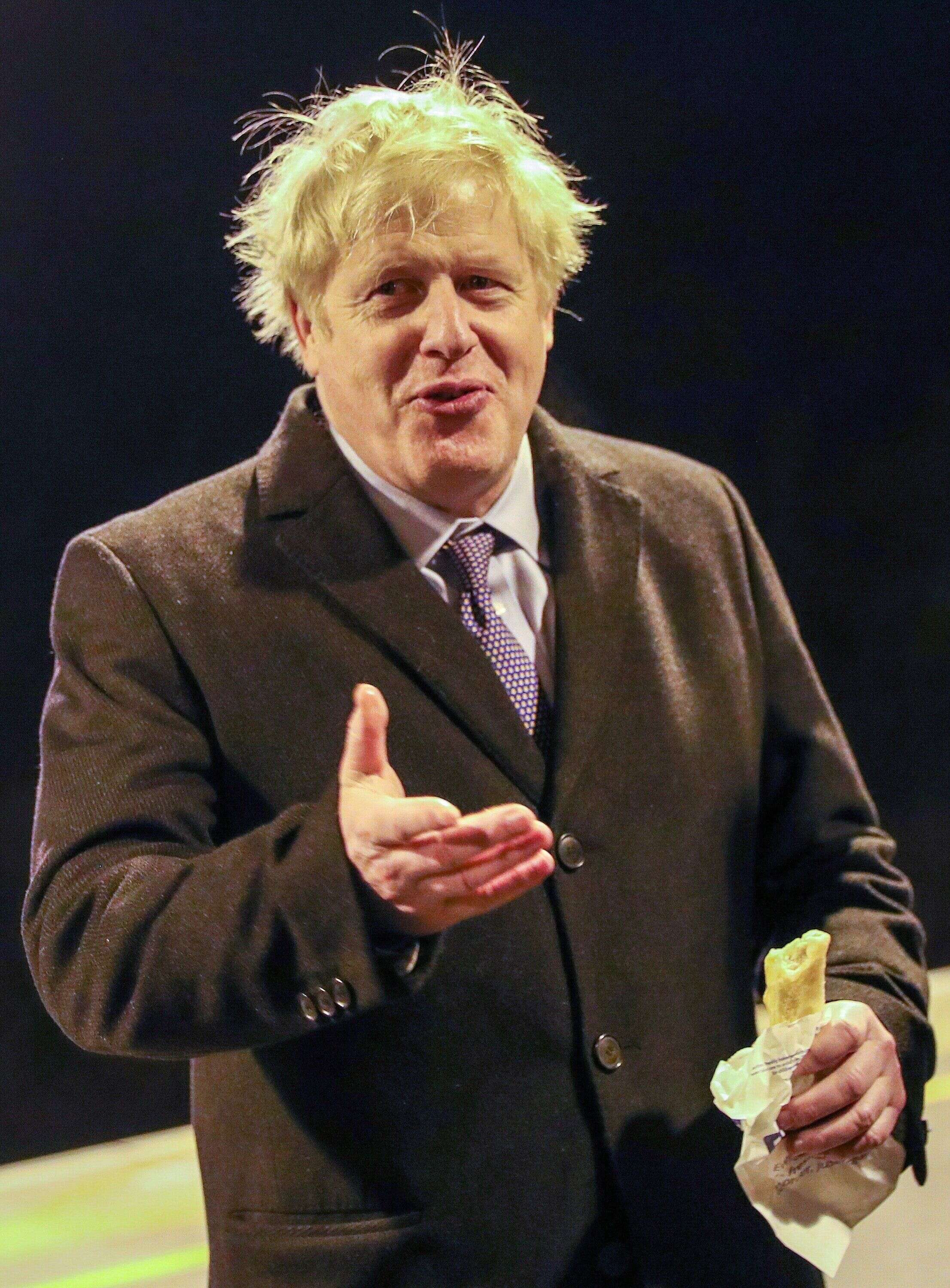 Britain's Prime Minister Boris Johnson gestures as he holds a 