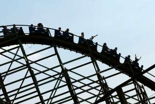Photo prise le 21 juillet 2004 à Plailly, de personnes sur le manège de la montagne russe, l'une des attractions du parc Astérix. Le parc à thème français, créé en 1989, appartient au groupe Grévin & Cie. (Photo by JOEL ROBINE / AFP)