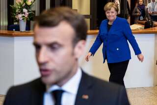 France's President Emmanuel Macron talks to journalists as Germany's Chancellor Angela Merkel walks behind him after a European Council meeting on Brexit at The Europa Building at The European Parliament in Brussels on April 11, 2019. - European leaders agreed with Britain on Thursday to delay Brexit by up to six months, saving the continent from what could have been a chaotic no-deal departure at the end of the week. The deal struck during late night talks in Brussels means that if London remains in the EU after May 22, British voters will have to take part in European elections. (Photo by KENZO TRIBOUILLARD / AFP)        (Photo credit should read KENZO TRIBOUILLARD/AFP/Getty Images)