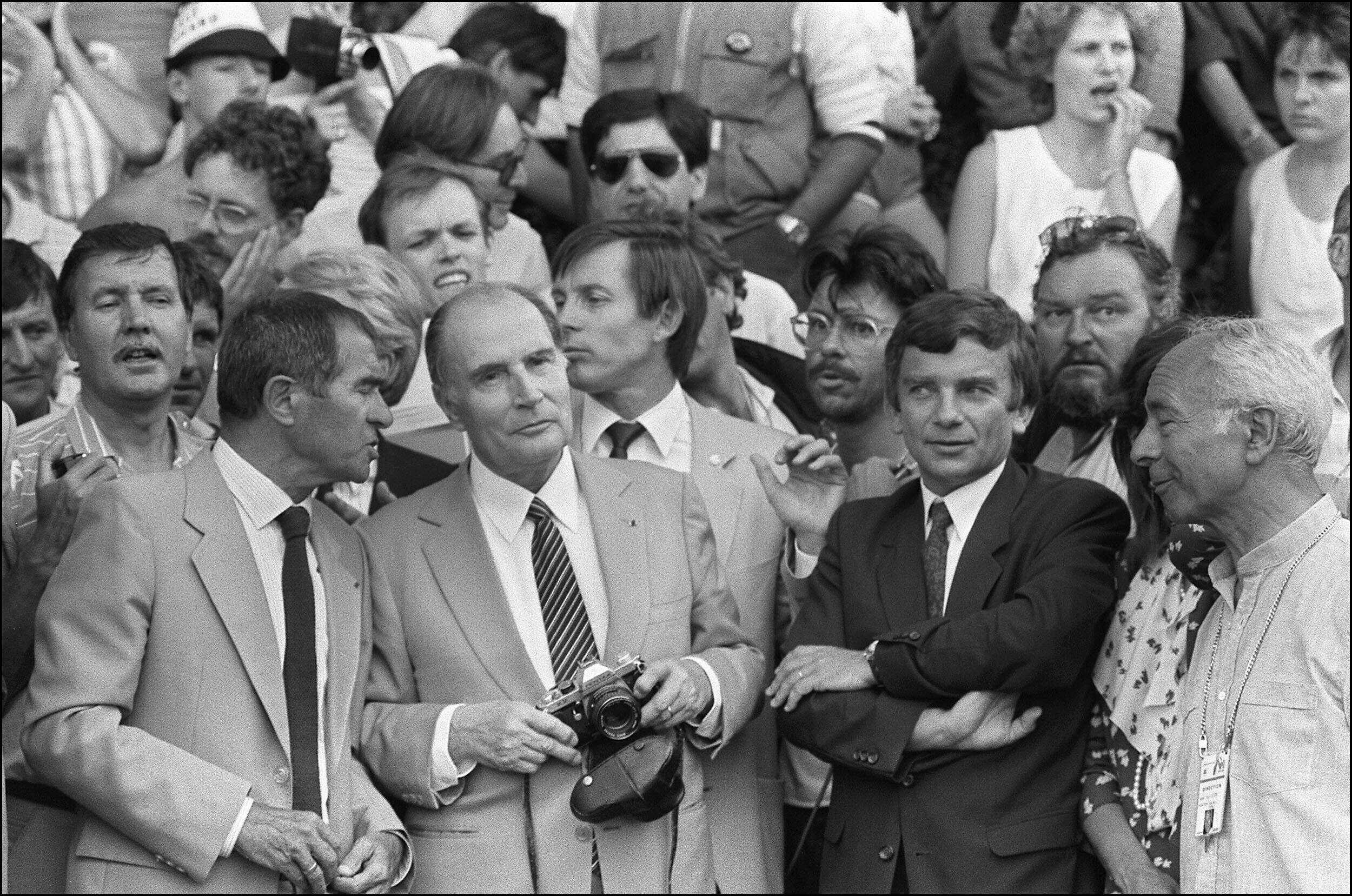 François Mitterrand, appareil photo en main, immortalise le passage des coureurs du Tour de France notamment le maillot jaune Bernard Hinault lors de l'étape Morzine-Villard de Lans, le 10 juillet 1985.