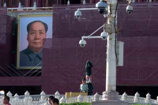 Un policier placé aux abords de la place Tiananmen et devant un portrait de Mao Zedong, en mai 2019