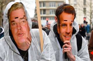 Des manifestants portent des masques représentant le président Emmanuel Macron et le haut-commissaire à la réforme des retraites Jean-Paul Delevoye, lors d'une manifestation à Rennes dans le cadre d'une sixième journée de grève massive contre le projet du gouvernement de réformer le système de retraite, le 10 décembre 2019.