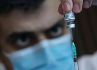Un soignant extrait une dose du vaccin Pfizer/BioNtech en Belgique, le 21 janvier 2021. (REUTERS/Yves Herman)