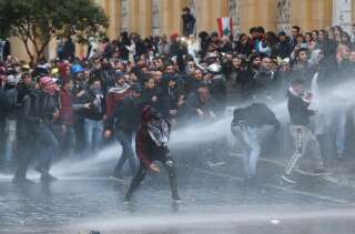 Des manifestants sont frappés par un canon à eau lors d'une manifestation contre une élite dirigeante accusée d'avoir conduit le Liban à la crise économique, à Beyrouth, au Liban, le 18 janvier 2020.