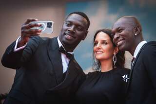 Omar Sy, avec Helene Sy et Alassane Diong, transgresse les règles pour un selfie sur les marches du Festival de Cannes, le 18 mai 2022 lors de la projection de 