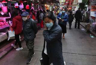 Dans les rues de Hong Kong, les gens se protègent avec des masques.