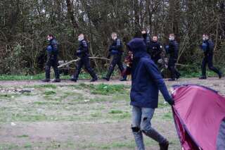 Le 28 novembre 2021, des agents de police détruisent un campement de personnes exilées à Calais. (Photo by Louis Witter/Getty Images)
