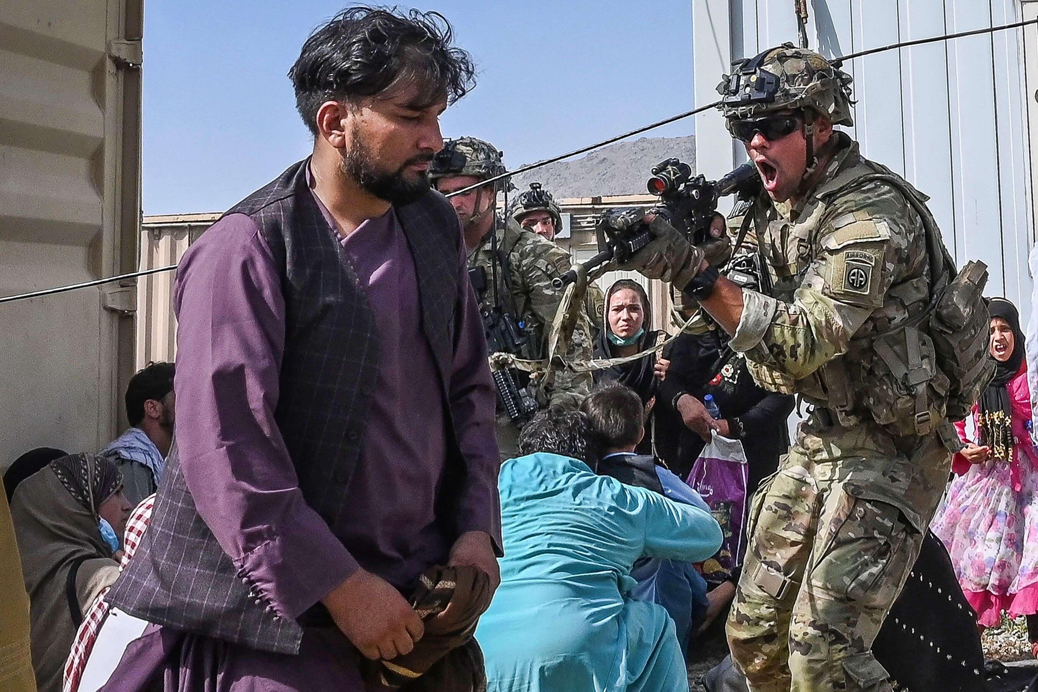 Alors qu'une foule d’Afghans s’est rendue à l’aéroport de Kaboul dans l'espoir de quitter le pays pris par les talibans, occasionnant des scènes de chaos et de panique, les soldats américains ont tenté de sécuriser l'aéroport, quitte parfois à tirer en l'air pour tenter de contrôler la foule, le 16 août 2021 à Kaboul, Afghanistan. (Photo by WAKIL KOHSAR/AFP via Getty Images)