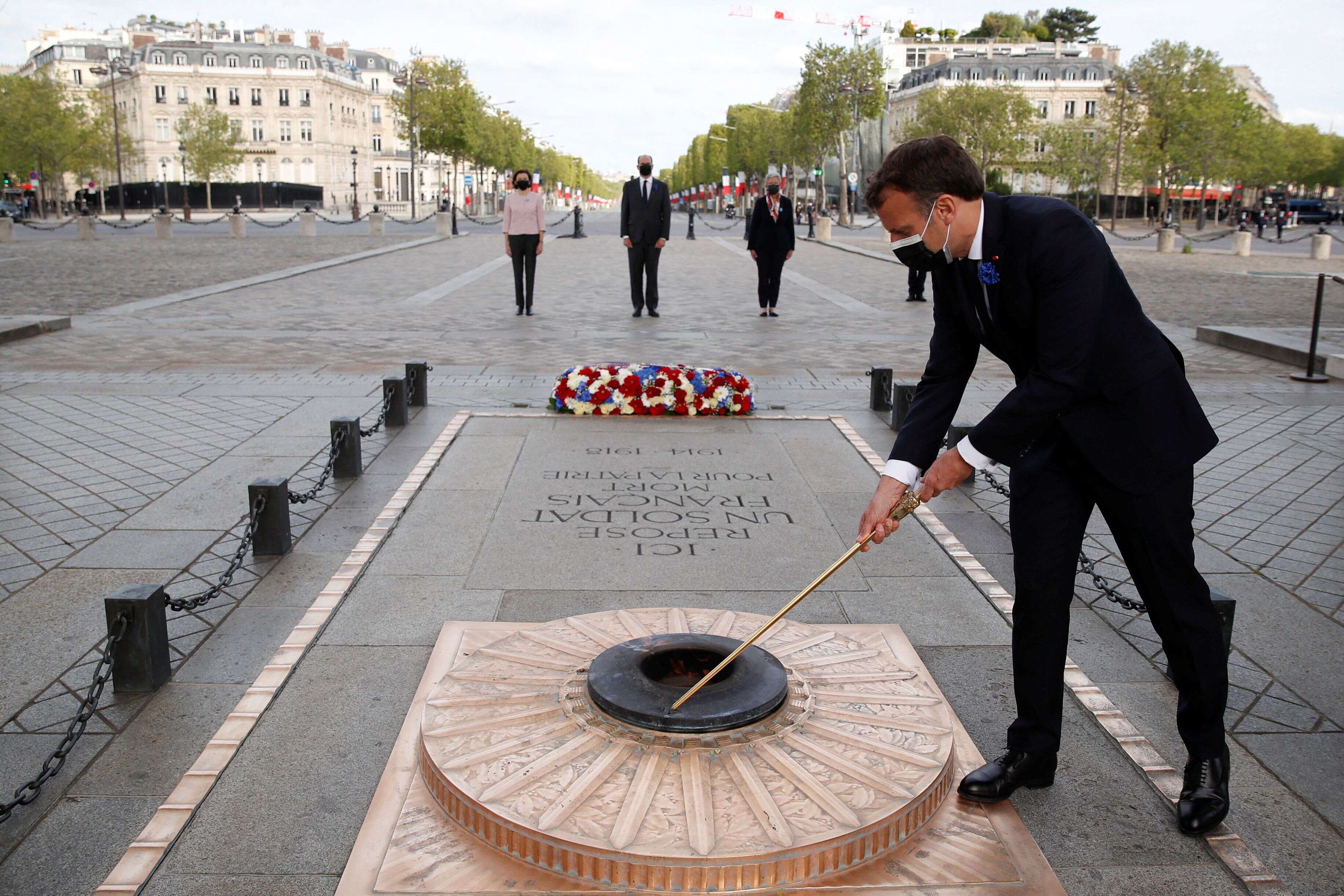 Emmanuel Macron, ici allumant la flamme sur la tombe du Soldat inconnu lors de la cérémonie du 76e anniversaire de la Victoire du 8 mai 1945, à Paris, le 8 mai 2021.