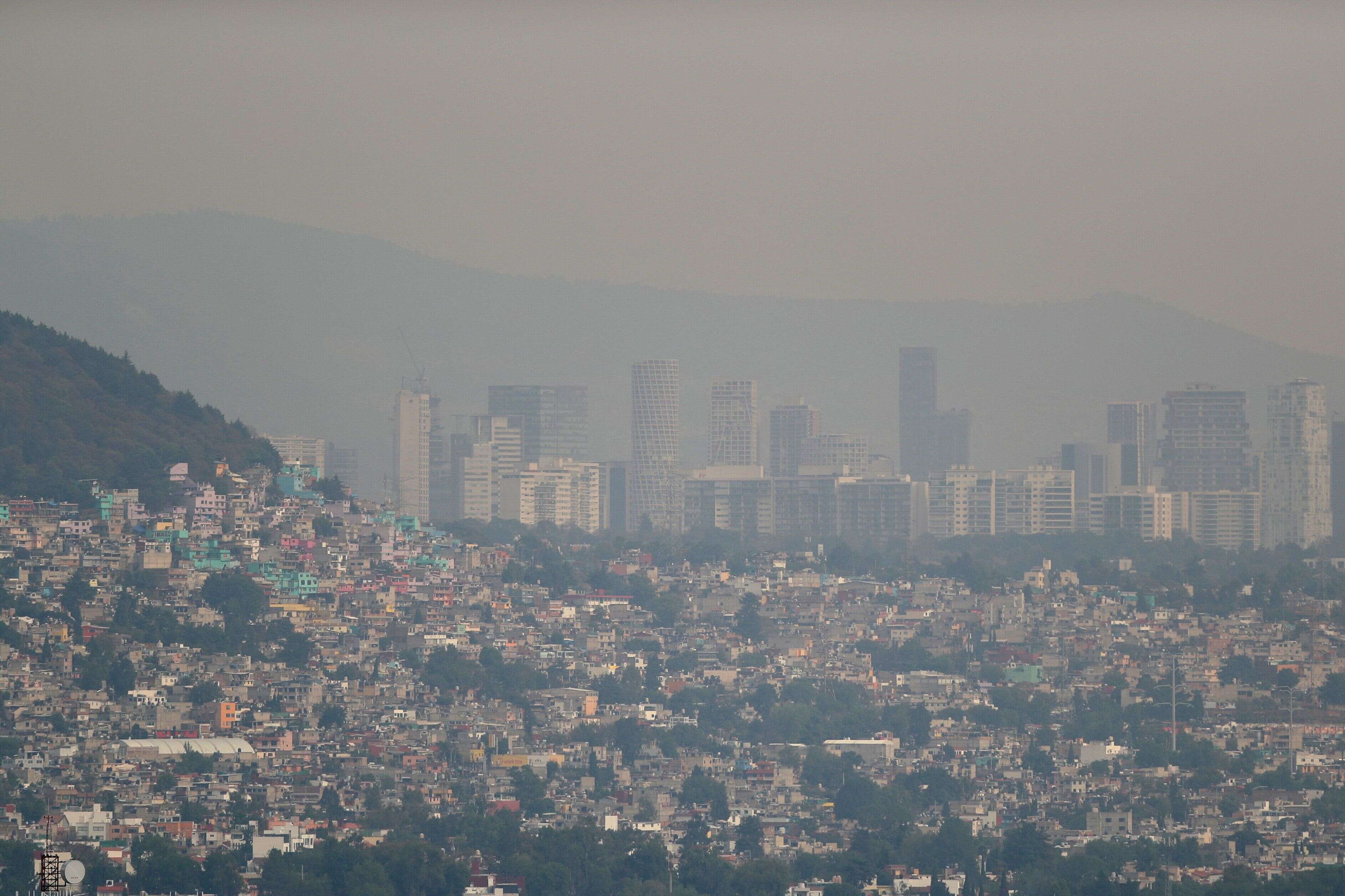 Buildings and houses stand shrouded in smog as authorities ordered traffic restrictions due to air pollution in Mexico City, Mexico, on May 3, 2022. REUTERS/Edgard Garrido