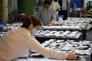 Des employés préparant des masques en tissu à l'usine de vêtements 