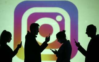 Des silhouettes devant un écran projettant le logo d'Instagram, le 28 mars 2018 (photo d'illustration).