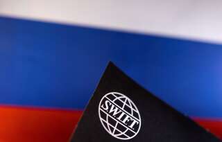 L'UE bannit des banques russes de Swift, mais épargne celles liées aux hydrocarbures (Photo du logo de Swift sur un drapeau russe le 25 février 2022. REUTERS/Dado Ruvic/Illustration)