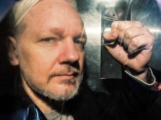 Le fondateur de WikiLeaks, Julian Assange, à la fenêtre d'un fourgon de prisonniers, lors de son transfert à la cour de justice de Londres en mai 2019, pour son procès qui le verra condamné à 50 semaines de prison pour avoir échappé à la justice en se réfugiant à l'ambassade équatorienne.