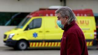 Un homme passe le 25 mars 2020 devant une ambulance à Valence, en Espagne, désormais deuxième pays le plus endeuillé par le coronavirus après l'Italie.