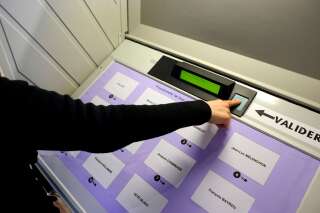 Un électeur clique sur un bouton pour voter avec une urne électronique, le 22 avril 2012, à Mulhouse, dans l'est de la France, dans le cadre du vote du premier tour de l'élection présidentielle. (Photo SEBASTIEN BOZON/AFP via Getty Images)