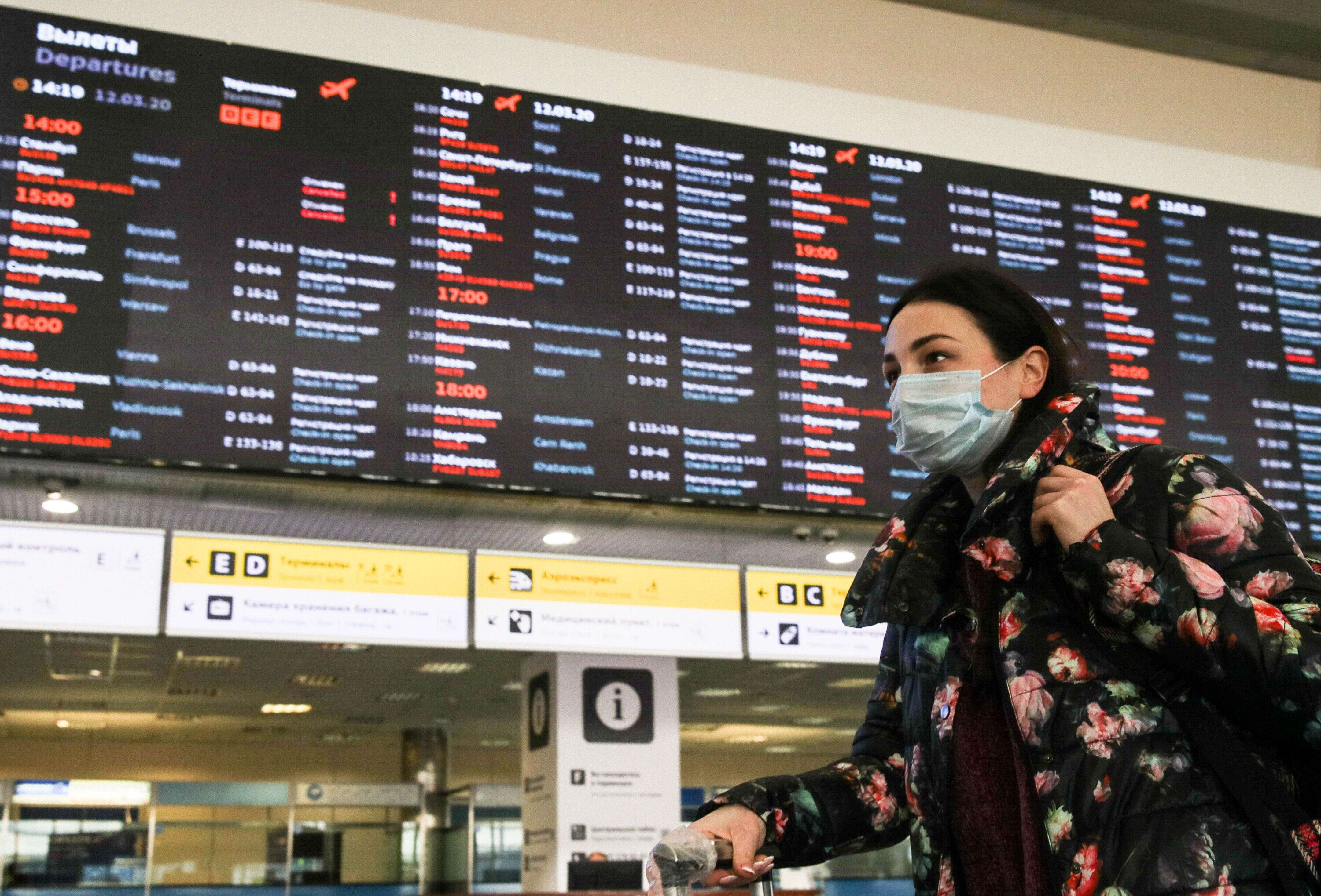 Une jeune femme portant un masque pour se protéger du coronavirus, le 12 mars 2020 dans un aéroport de Moscou.