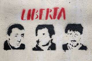 Une photographie prise le 14 mars 2022 à Bastia d'un graffiti à l'éfigie des trois hommes impliqués dans le commando du préfet Erignac, Yvan Colonna (à gauche), Alain Ferrandi (au centre) et Pierre Alessandri (à droite).