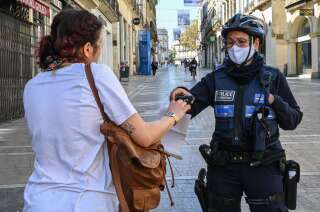 Une agente de la police municipale vérifiant l'attestation d'une passante, à Montpellier, le 10 avril 2020.