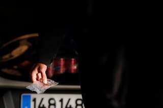 Une personne tient un sachet de résine de cannabis lors d'un contrôle du Peloton de surveillance et d'intervention-Sabre de la Gendarmerie nationale, à Bondoufle, au sud de Paris, le 11 juillet 2020. (Photo by GEOFFROY VAN DER HASSELT / AFP)