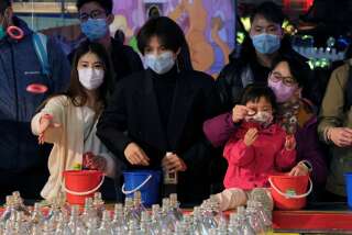 Visitors wear masks to prevent an outbreak of a coronavirus as they play at a carnival in Hong Kong, China January 28, 2020. REUTERS/Tyrone Siu