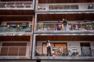 Des voisins discutant depuis leur balcon à Paris le 20 mars 2020.