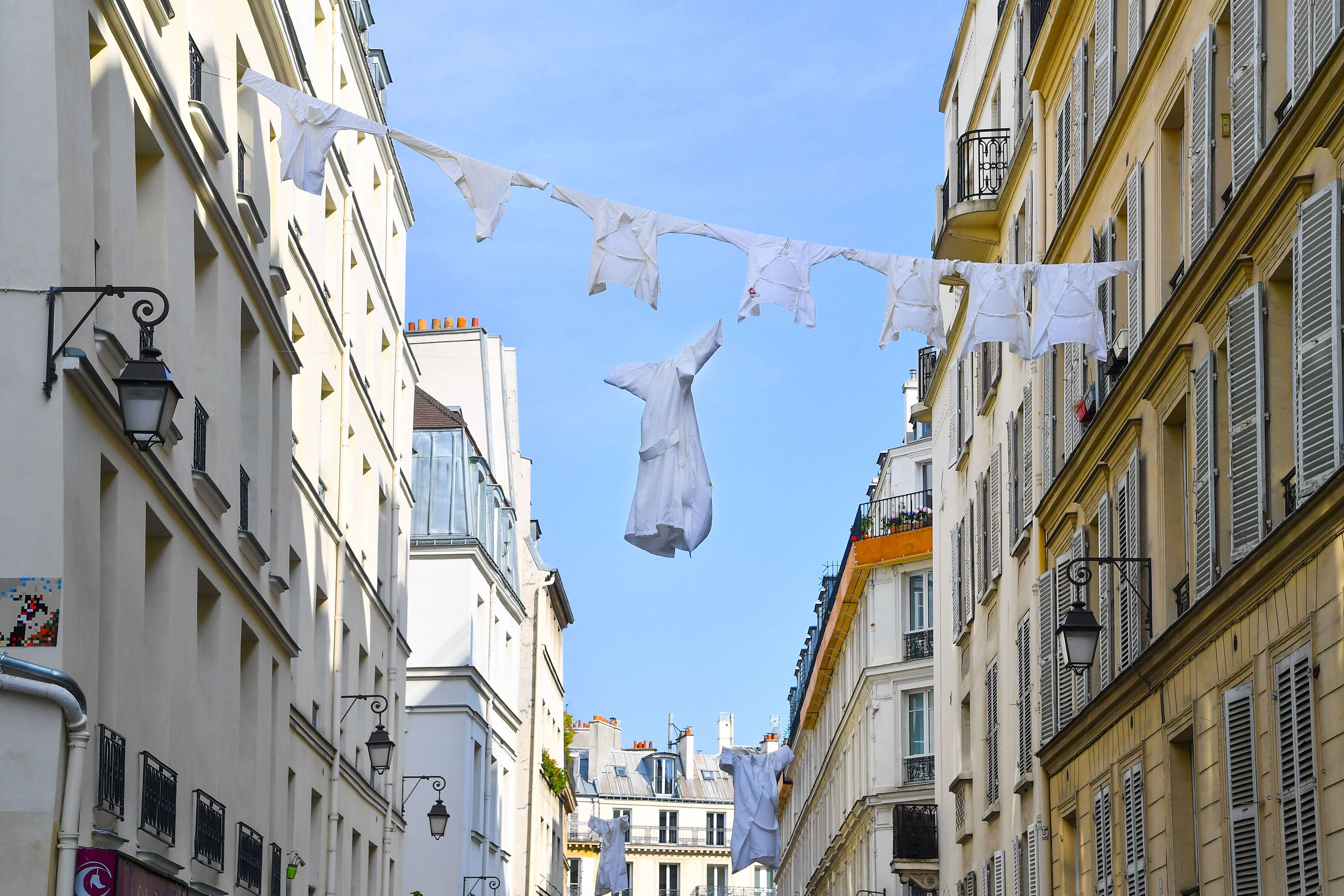 En hommage aux soignants, des blouses sont suspendues dans la rue durant le confinement, à Paris le 20 avril 2020.