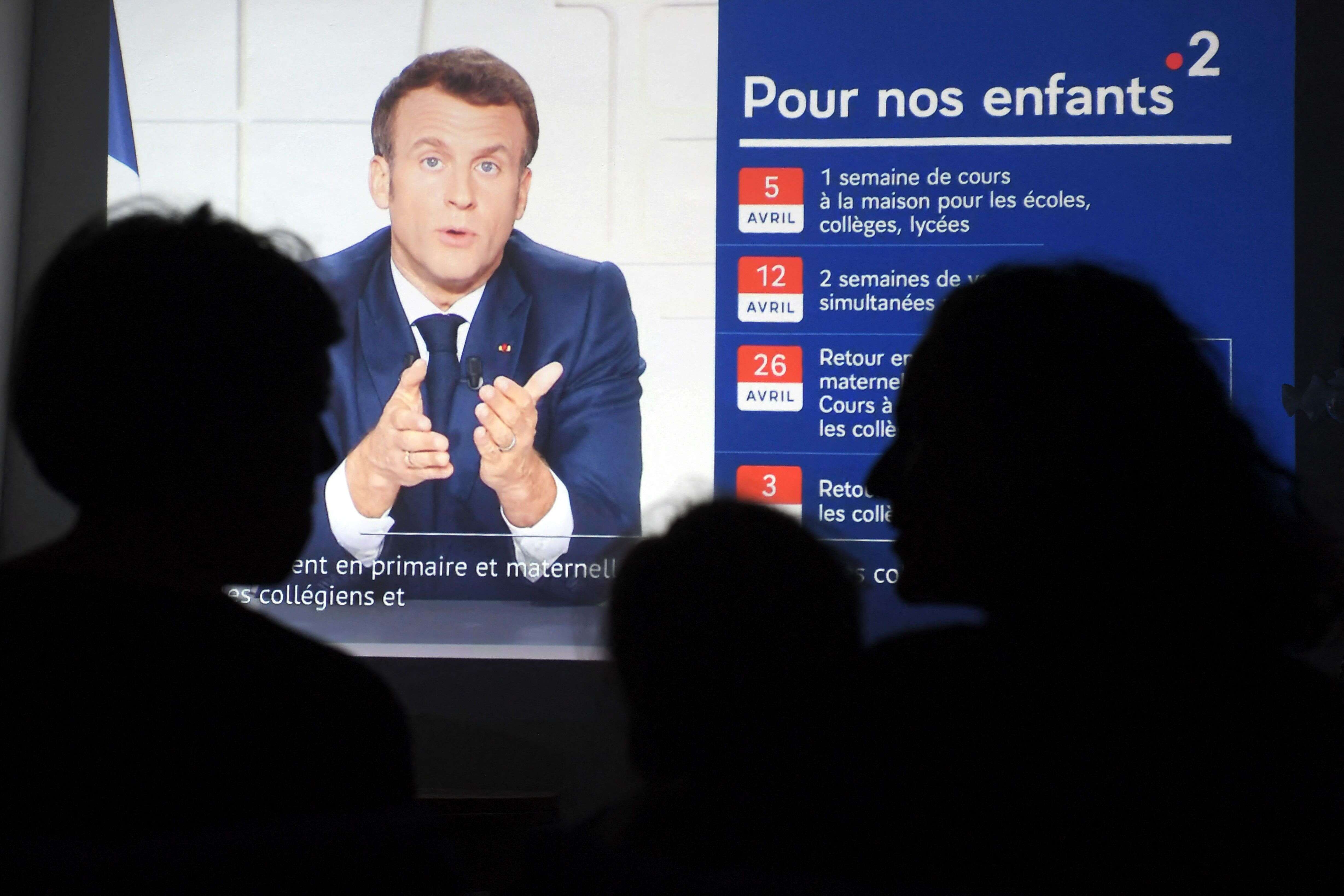 Des Français regardent l'allocution télévisée du Président Emmanuel Macron présentant les restrictions sanitaires renforcées contre le covid-19, le 31 mars 2021 (Photo by Nicolas TUCAT / AFP)