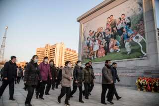Des personnes marchant devant une mosaïque représentant Kim Il Sung et Kim Jong Il, à Pyongyang en Corée du Nord, le 17 décembre 2021.