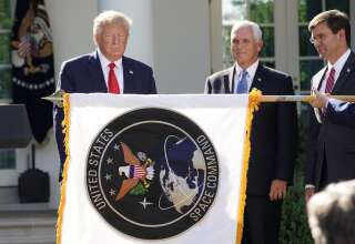 Donald Trump, son vice-président Mike Pence et son ministre de la Défense Mark Esper derrière le drapeau du nouveau commandement militaire de l'espace, ce 29 août à la Maison blanche.