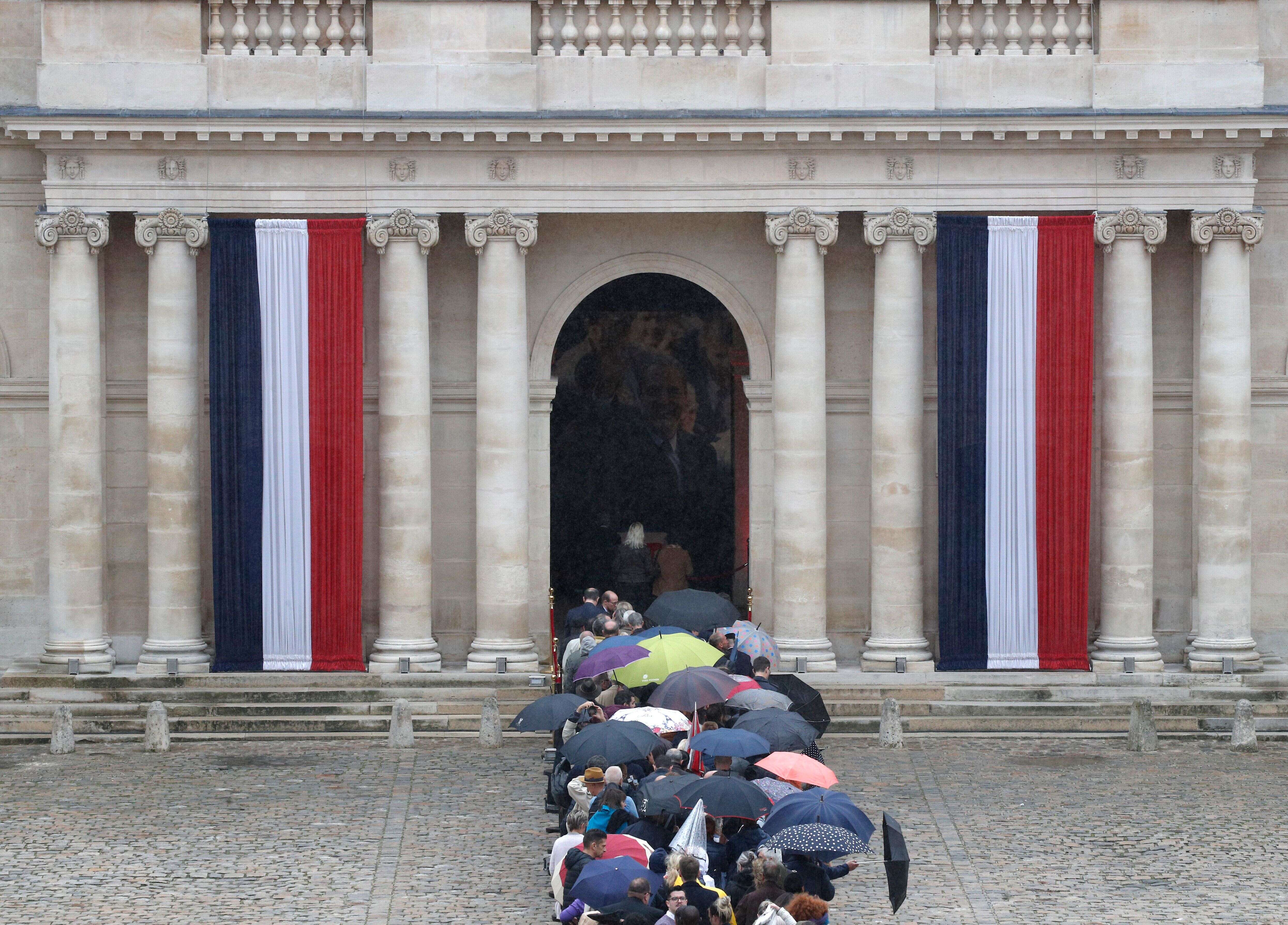 Le cercueil de Jacques Chirac, couvert de bleu blanc rouge, et entouré de drapeaux français et européen, sous un portrait géant de l’ancien président, a été placé à l’entrée de la cathédrale Saint-Louis des Invalides.
