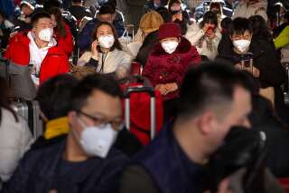 Des voyageurs portent des masques de protection à la gare ferroviaire de Pékin, le 21 janvier. En Chine, le coronavirus a désormais fait plus de morts de que le Sras en 2002-2003.