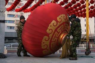 Des agents démontent des décorations du Nouvel an chinois, dont les festivités ont été annulées à Pékin à cause de l'épidémie de coronavirus.
