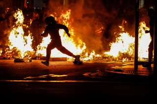 Vendredi explosif à Barcelone après quatre nuits de violences (ici un militants devant des barricades en feu à Barcelone le 17 octobre)