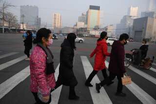 Des personnes traversant une route de Pékin, en Chine, le 11 février 2020 (photo d'illustration).