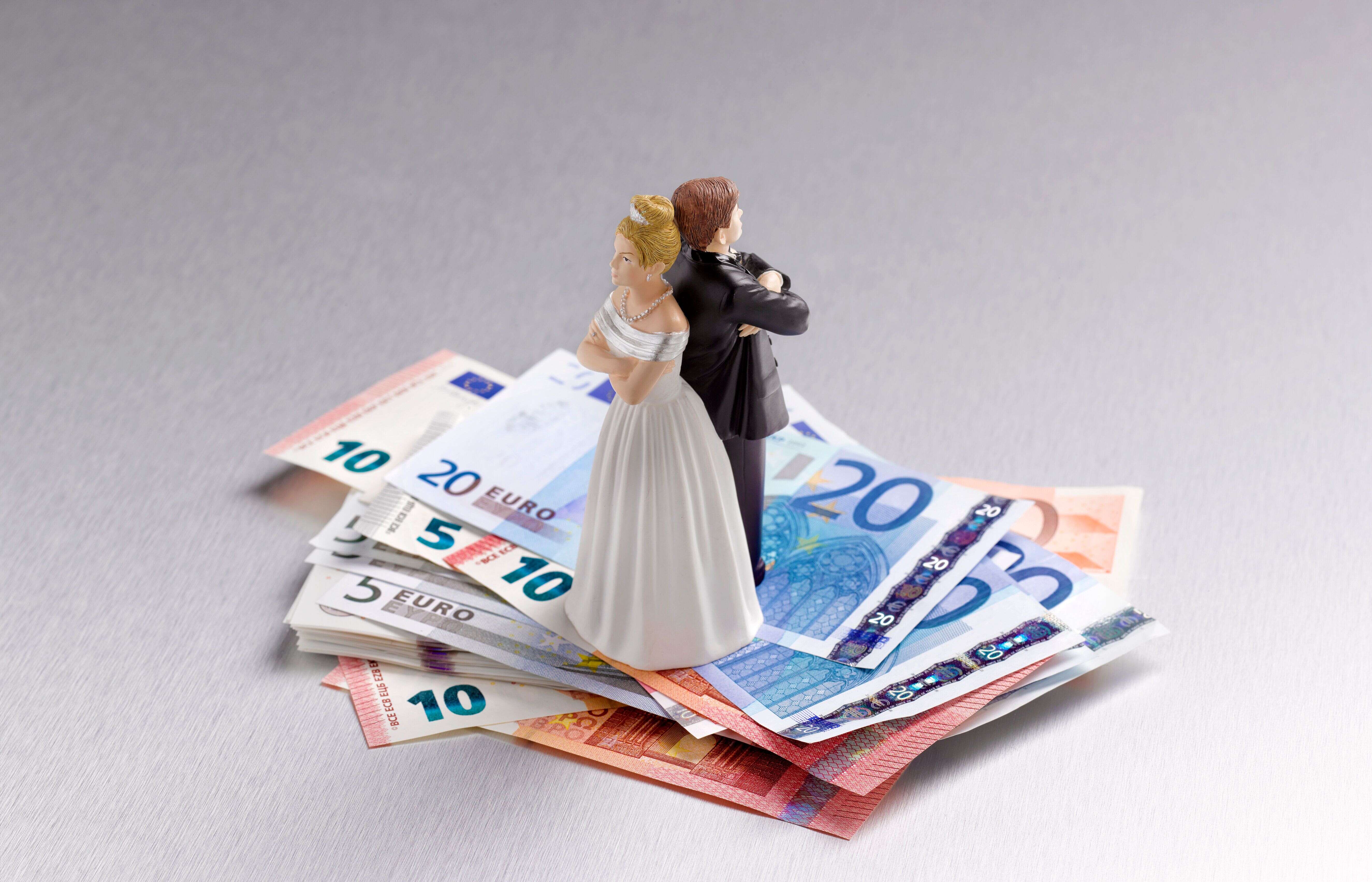 Wedding figurine couple back to back on a pile of Euros