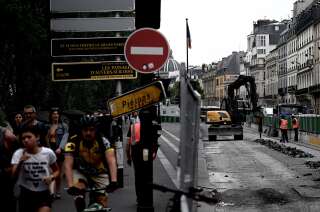 Des piétons et cyclistes se fraient un chemin dans une rue en travaux, à Paris, le 11 juillet 2019.