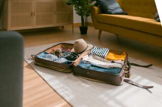 View of an open suitcase full of clothes ready to travel. Holidays and travel concept.