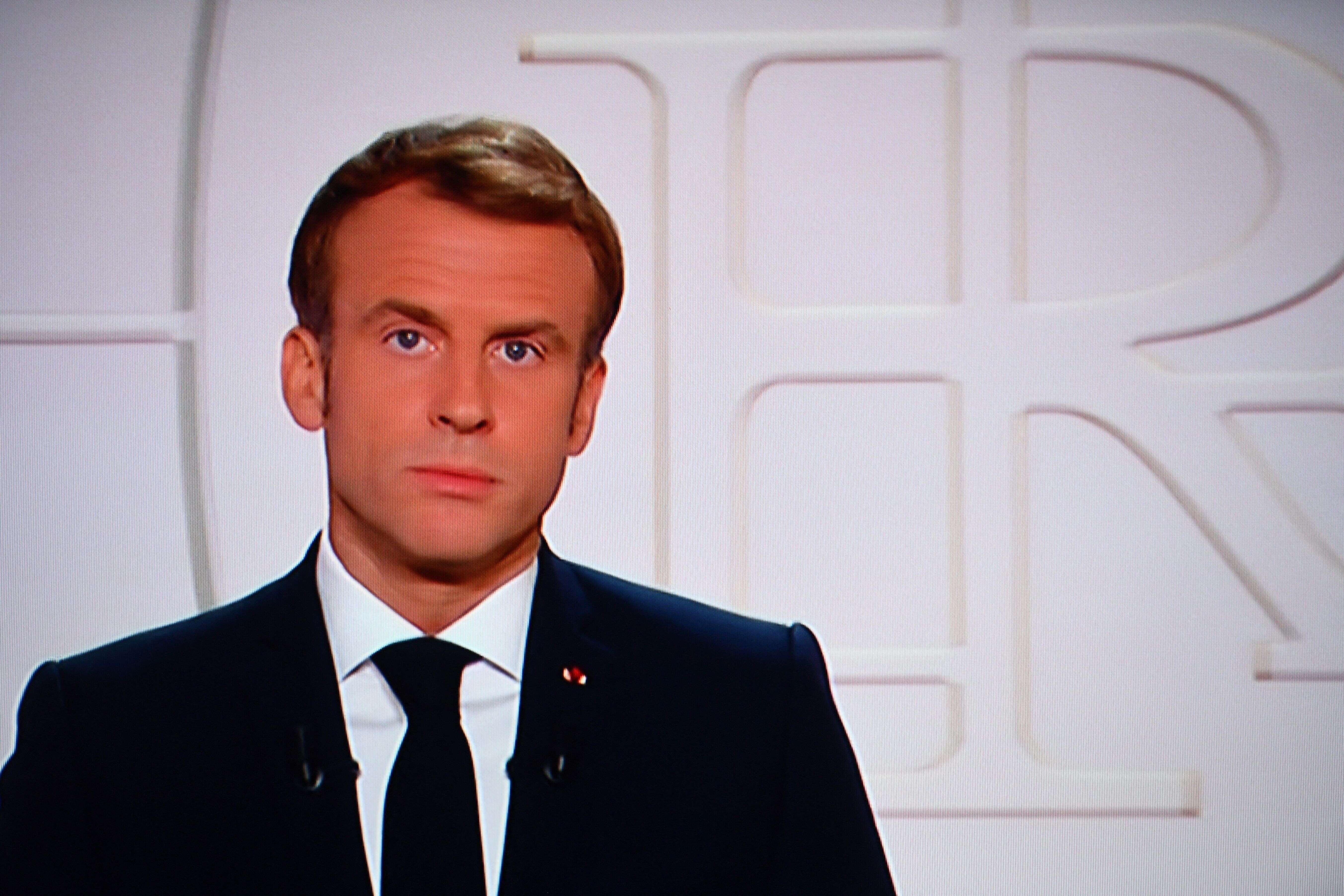 France's President Emmanuel Macron appears on a TV screen as he addresses to the nation on Covid-19 and reforms in Paris on November 9, 2021. - For the ninth time since the beginning of the Covid-19 crisis, Emmanuel Macron solemnly addresses the French to boost the vaccine recall in the face of the rebound of the epidemic, to boast of his record and to evoke the priorities of the end of the five-year term. (Photo by Christophe ARCHAMBAULT / AFP) (Photo by CHRISTOPHE ARCHAMBAULT/AFP via Getty Images)