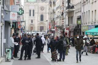 Des policiers français contrôlent l'attestation de sortie d'un homme à Saint-Denis, le 6 avril 2020, pendant le confinement.