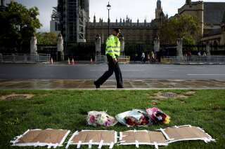 Un officier patrouille devant un des lieux en hommage au député David Amess, assassiné alors qu'il tenait sa permanence parlementaire près de Londres. REUTERS/Henry Nicholls