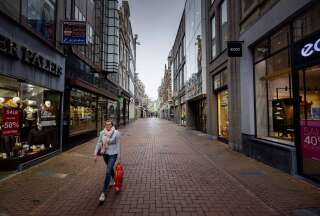 Une passantes dans les rues d'Amsterdam vides le 15 décembre 2020 (Photo by ROBIN VAN LONKHUIJSEN / ANP / AFP) / Netherlands OUT