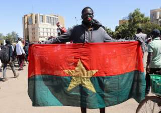 Un homme brandit son drapeau national pour afficher son soutien à l'armée après l'arrestation du président du Burkina Faso Roch Kaboré ce 24 janvier.